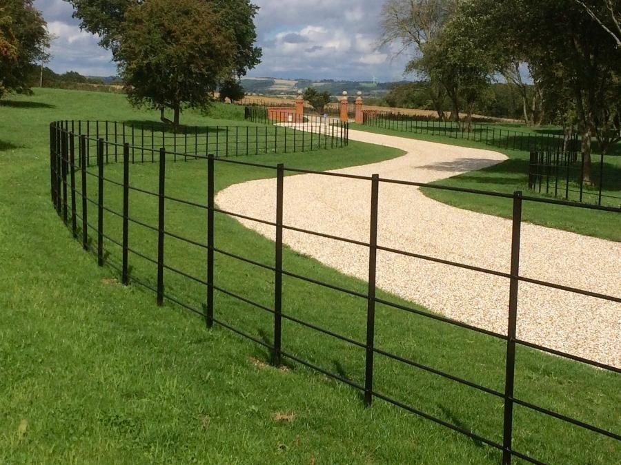 Beautiful sweeping gravel driveway bordered by metal fencing