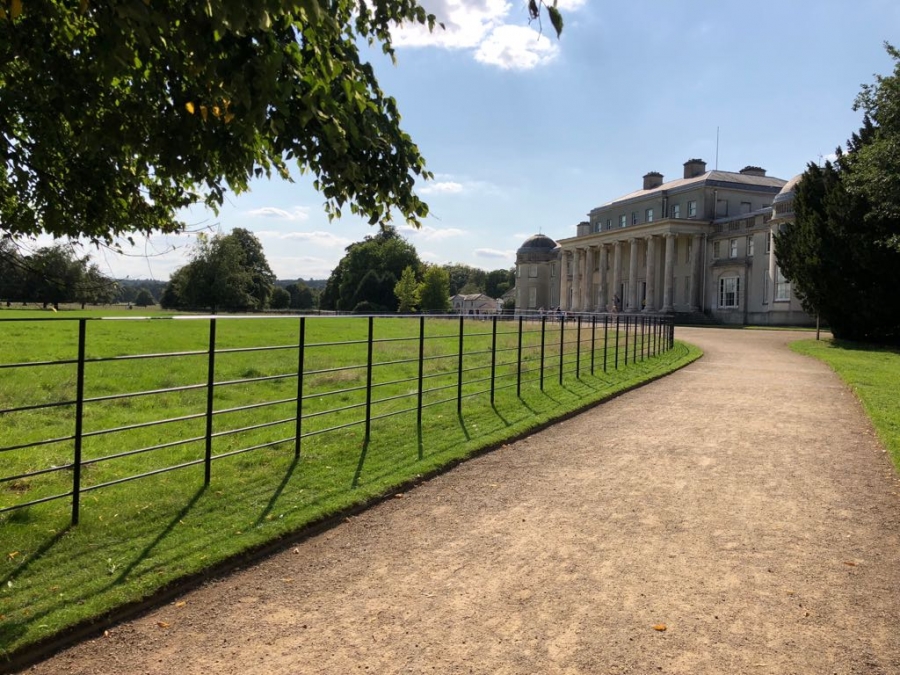 A driveway sweeps towards the portico of a country house,
